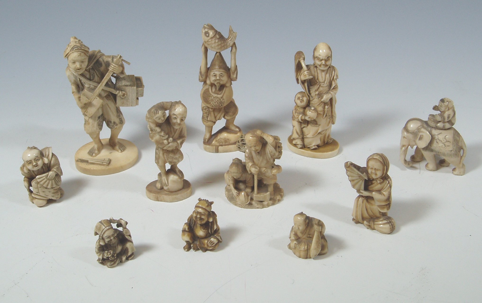 A collection of eleven small carved ivory figures,