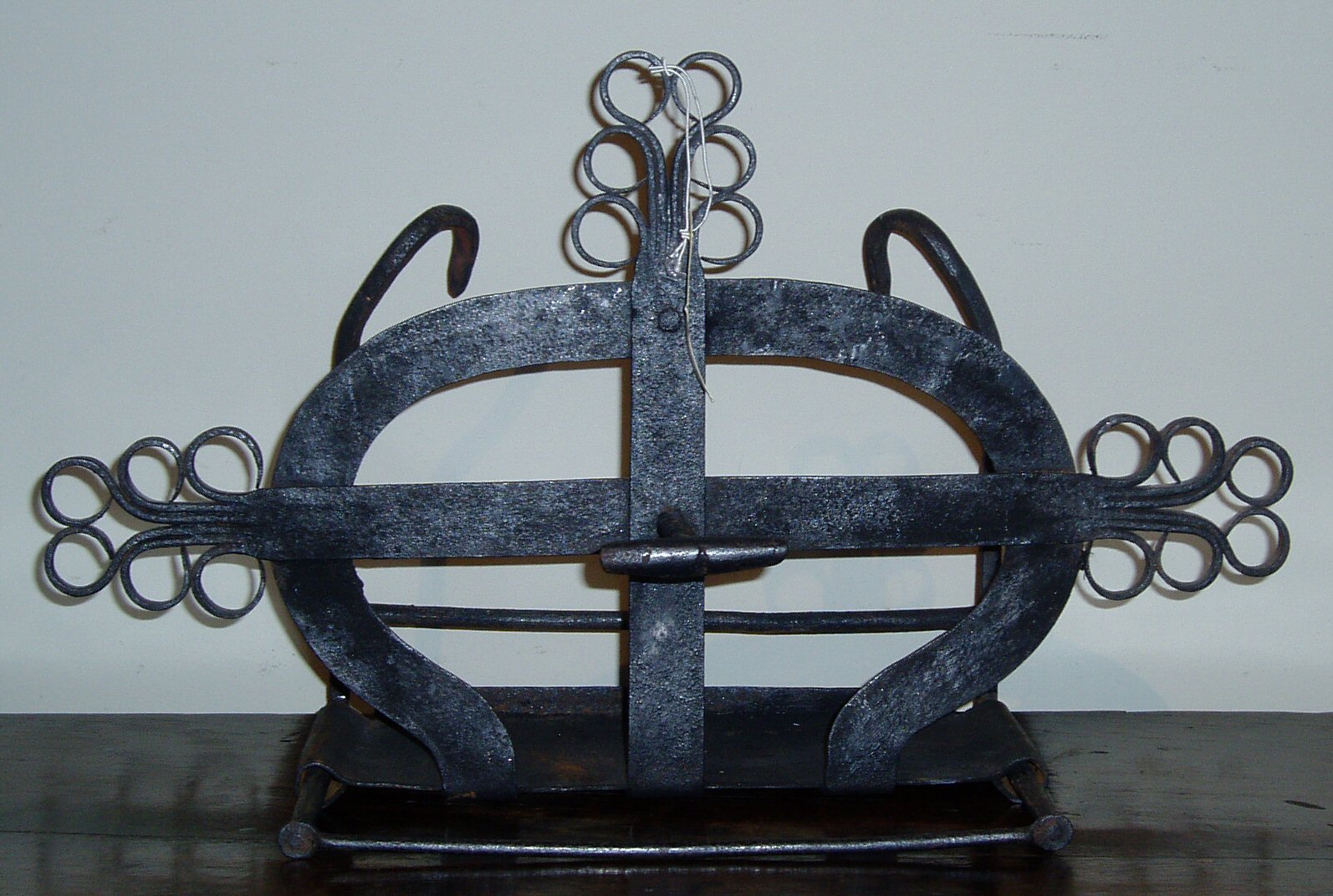 A Scottish wrought iron scroll decorated bannock toaster,
