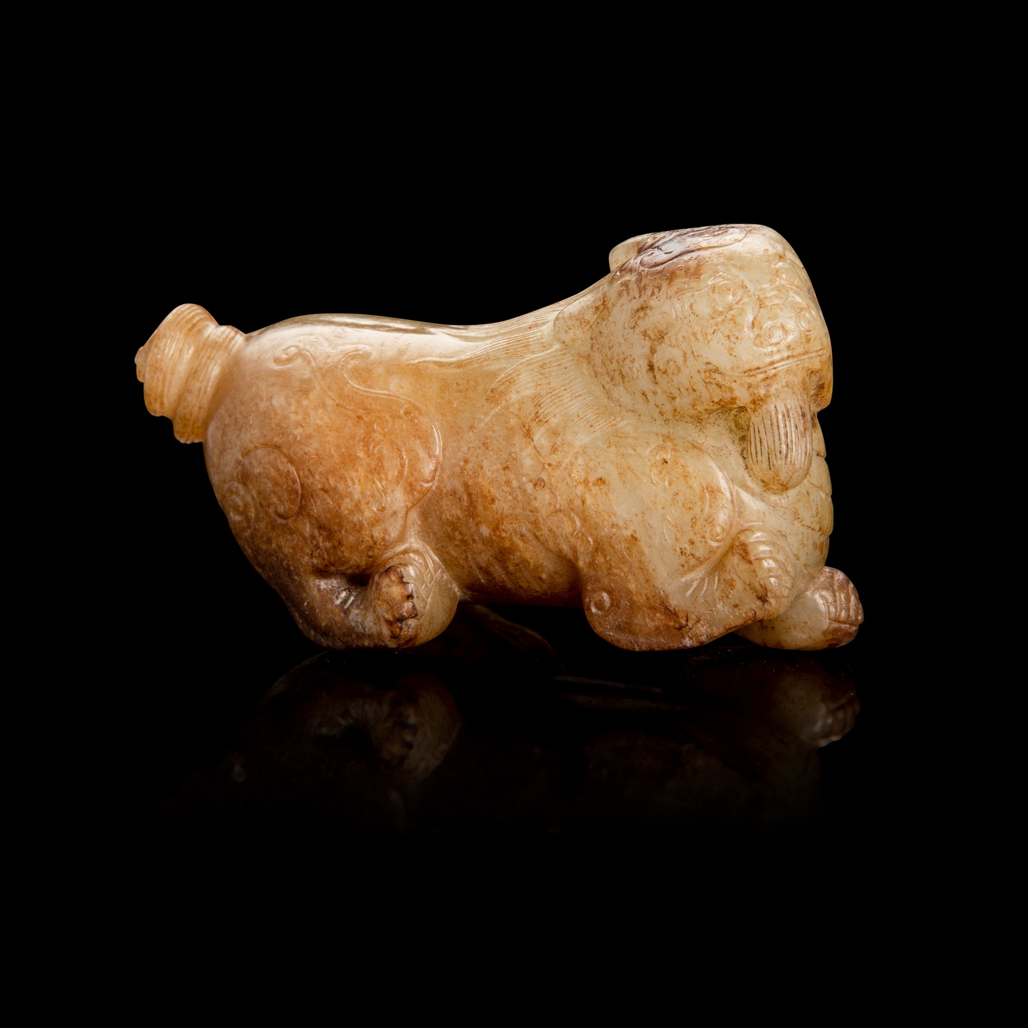 PALE CELADON AND RUSSET JADE CARVING OF A MYTHICAL ANIMAL