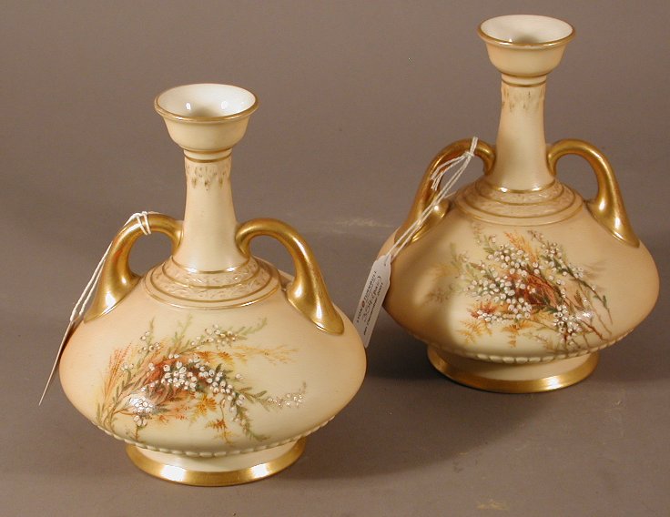 A pair of Royal Worcester twin handled baluster vases