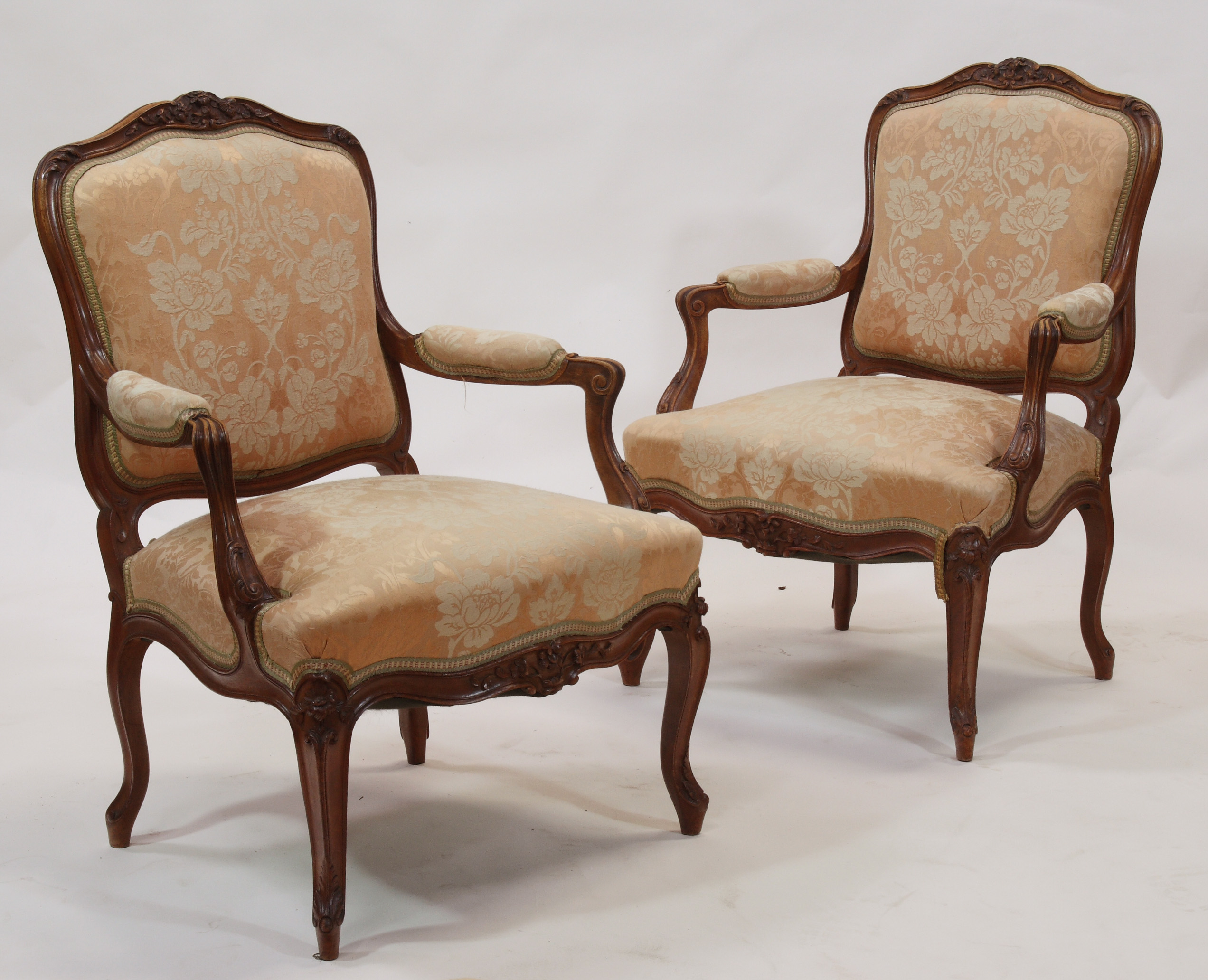 A pair of 19th century walnut framed fauteuils In the Louis XV manner