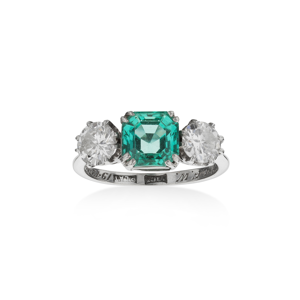 An emerald and diamond set three stone ring