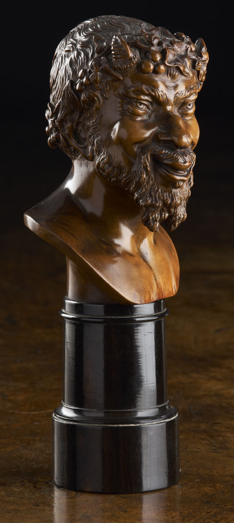 A small 19th century carved walnut bust of Bacchus
