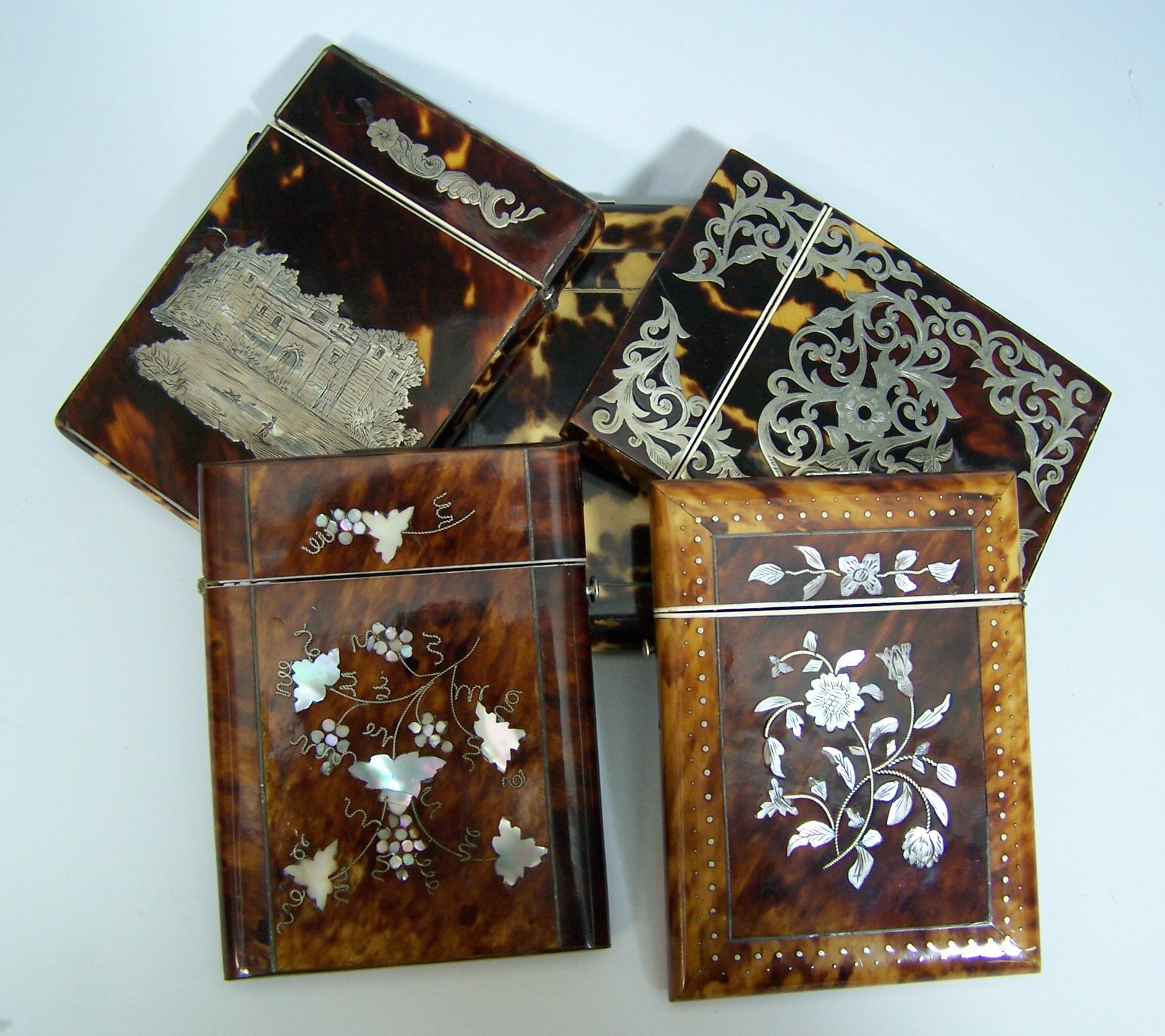 A collection of five tortoise shell card cases,