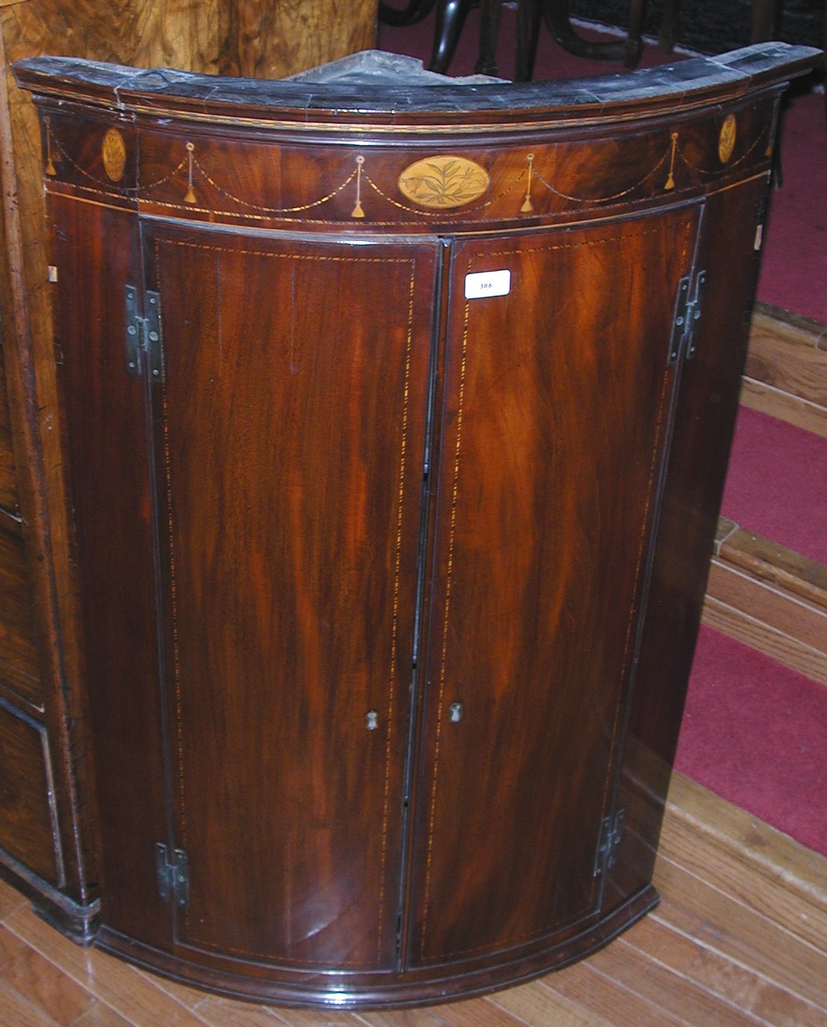 A George III mahogany and chequer strung bowfront corner cupboard,