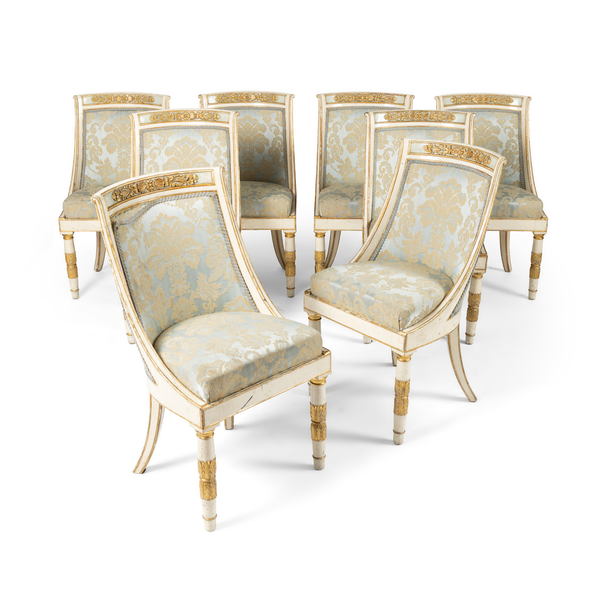A SET OF EIGHT FRENCH EMPIRE STYLE CREAM AND GILT DECORATED SIDE CHAIRS