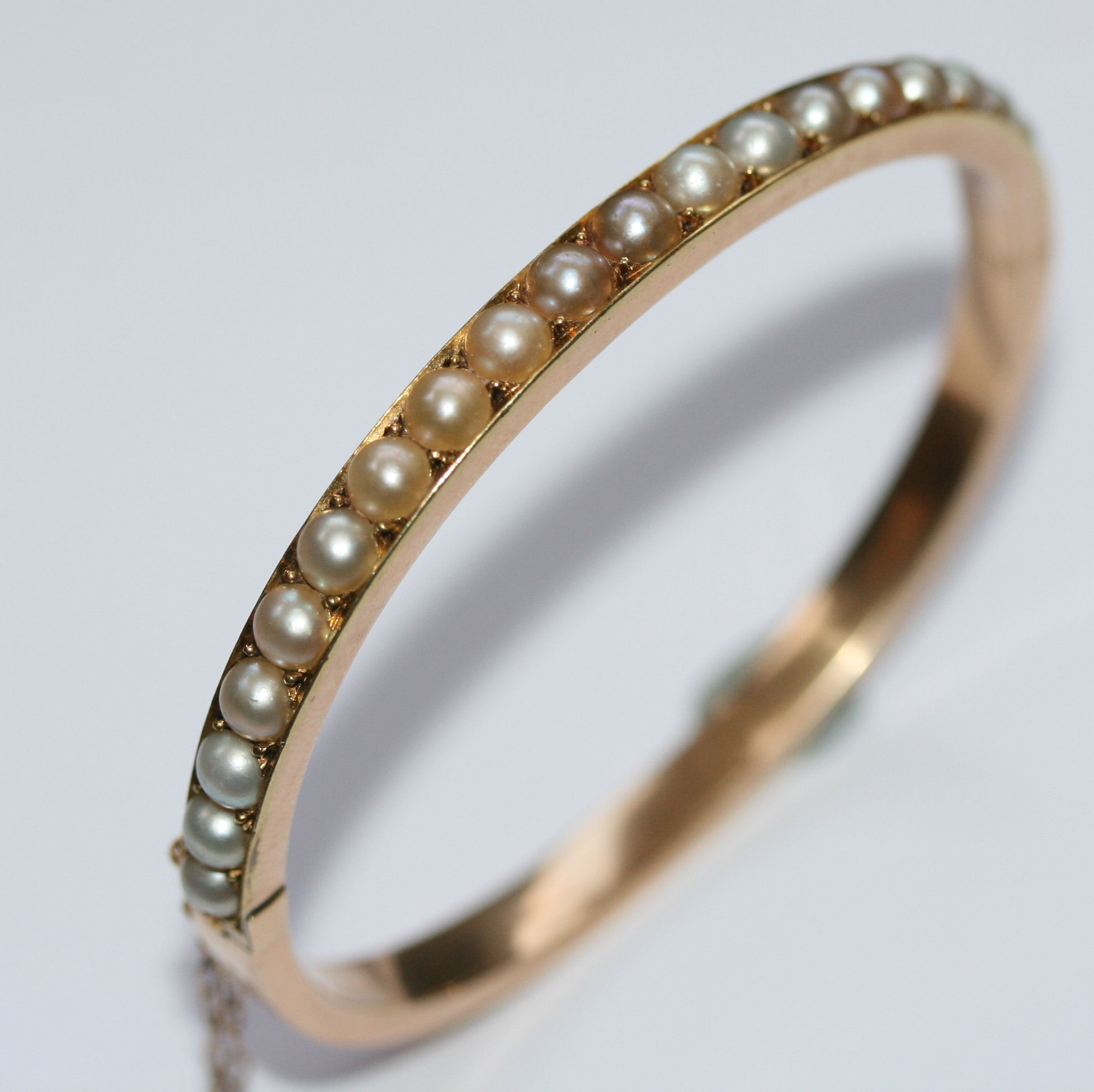 A pearl set hinged gold bangle