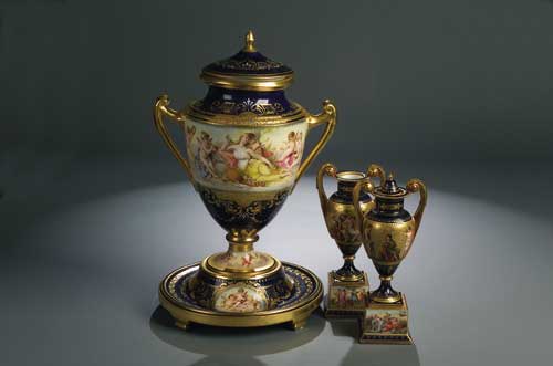 A pair of small Vienna twin handled urns and plinths