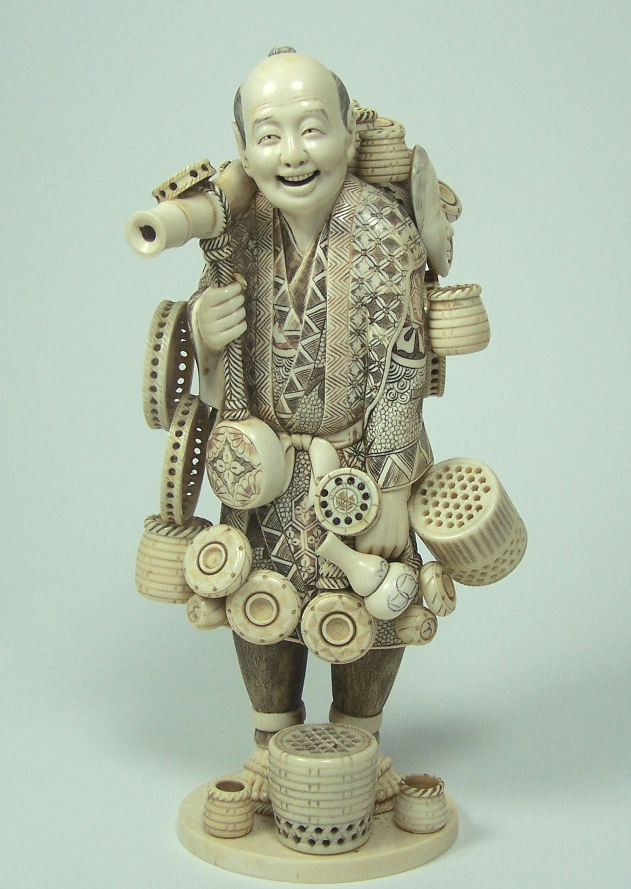 A large Japanese ivory figure of a basket seller, Meiji or Taisho period