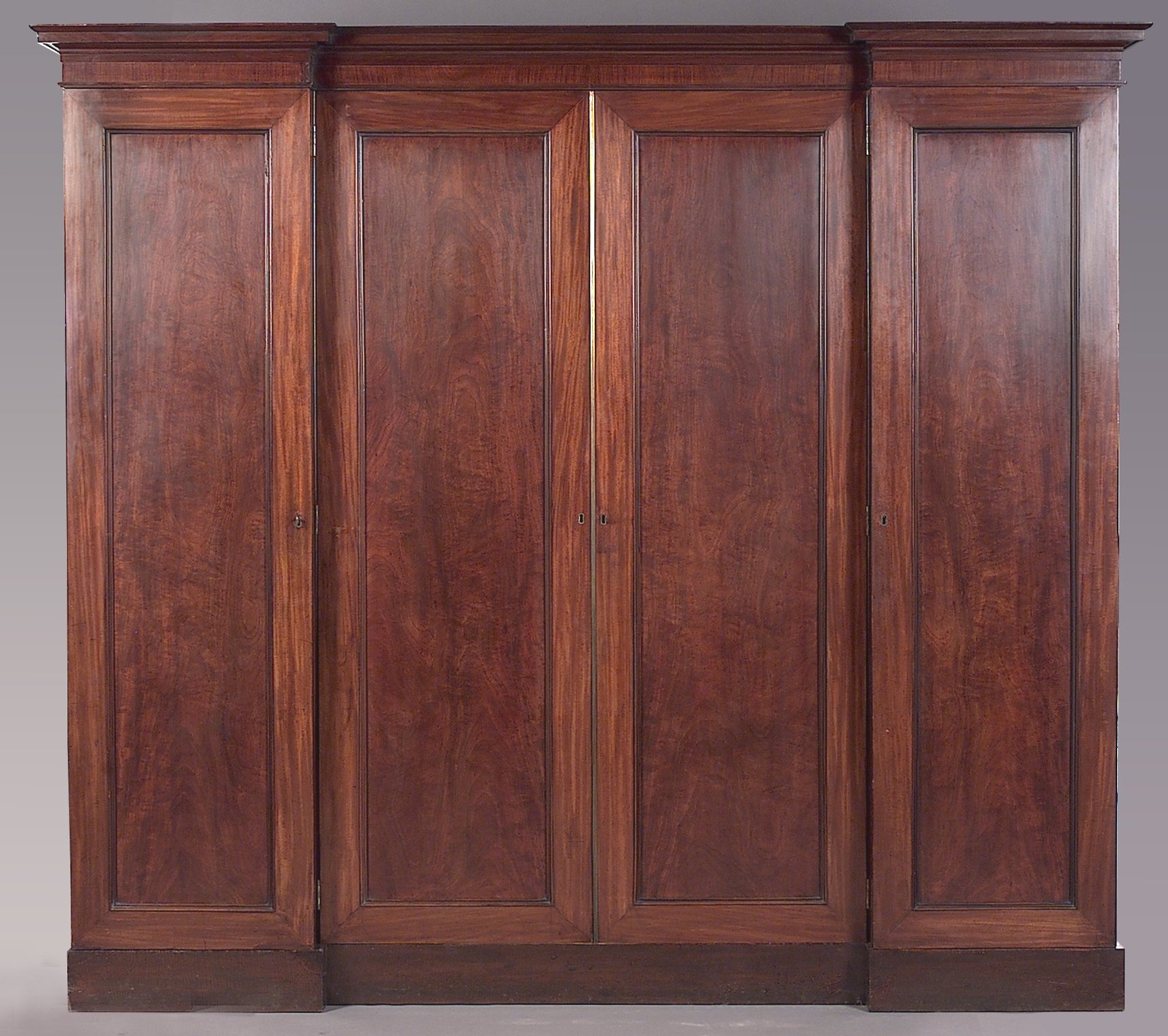 An early 19th century mahogany reverse breakfront wardrobe