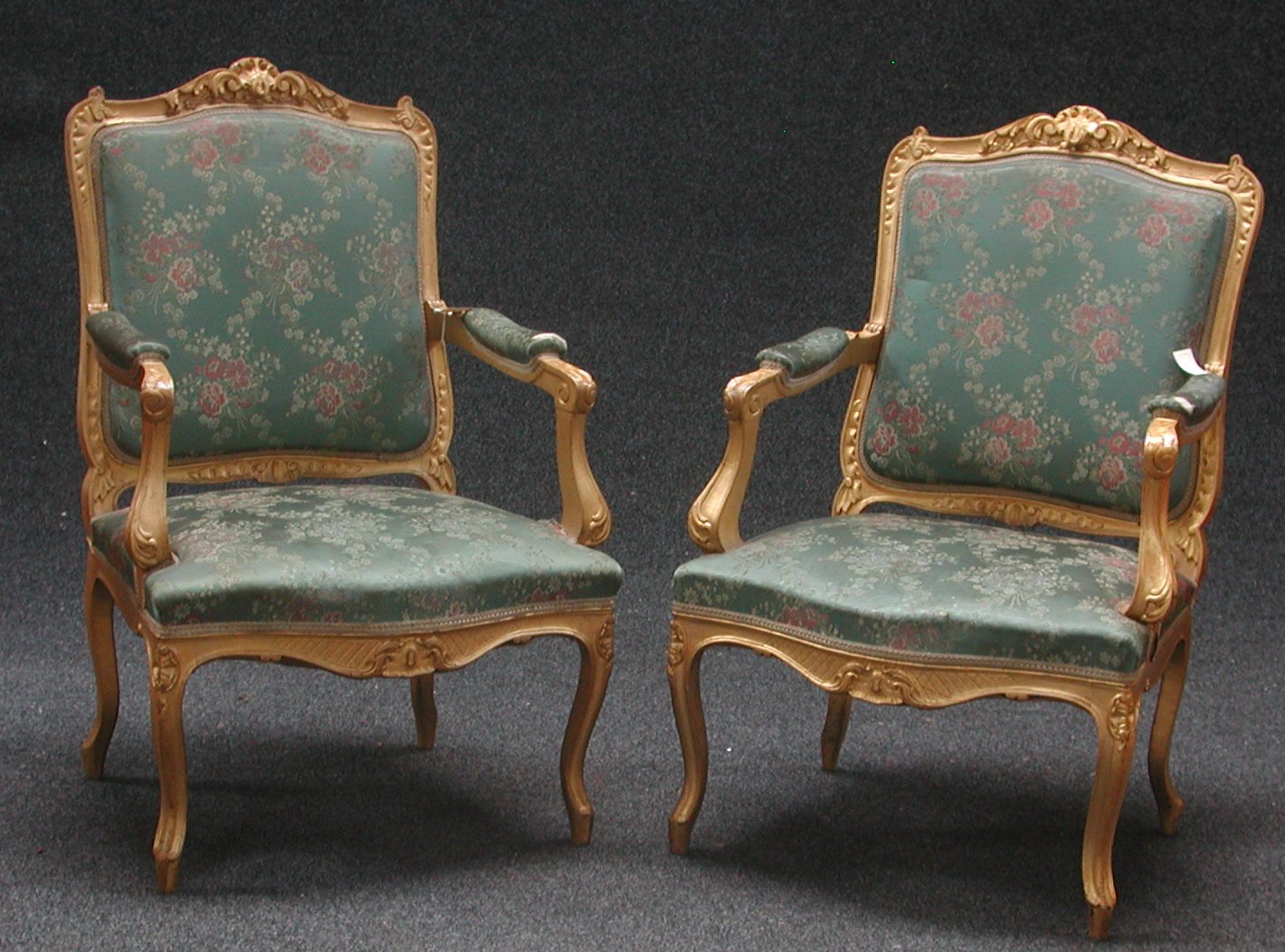 A pair of upholstered gilt armchairs,