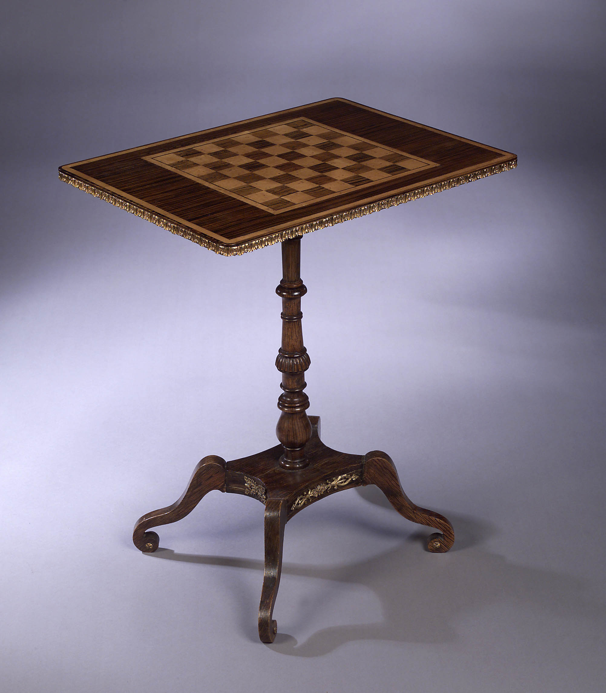 A Regency faux rosewood and maple inlaid games table