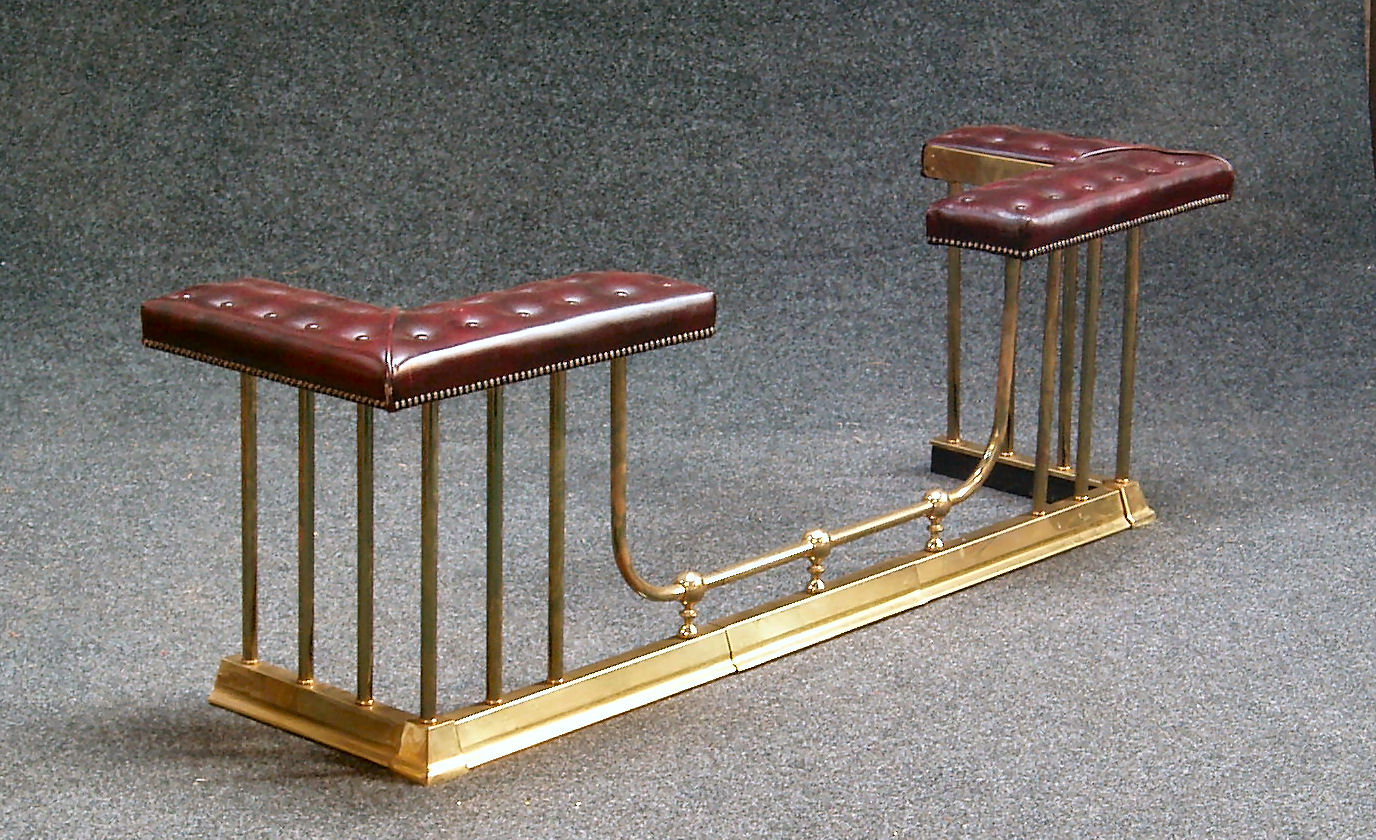 A brass and leather upholstered club fender,
