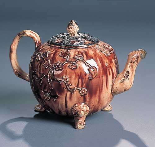 An English Whieldon type relief moulded treacle glazed baluster tea pot