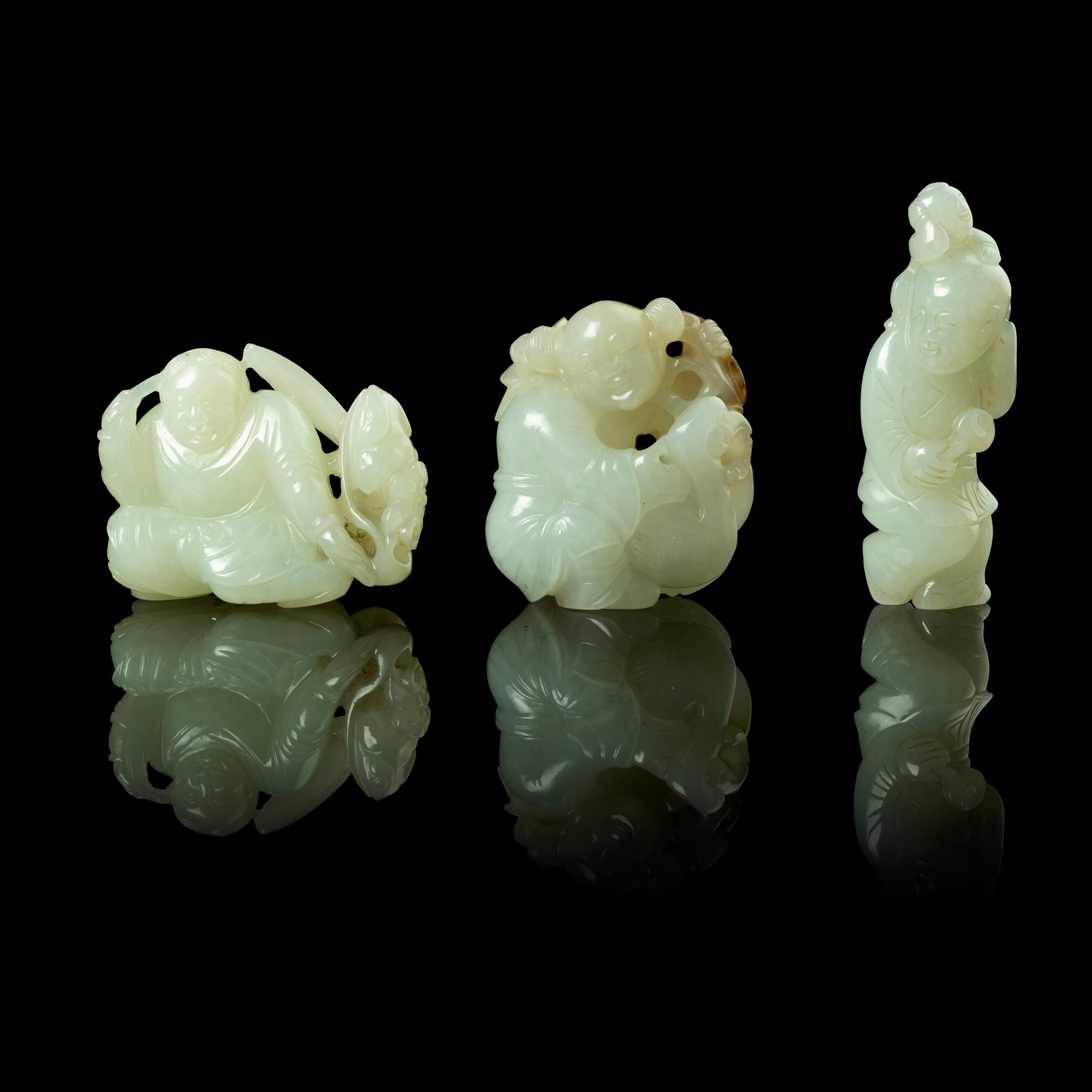 GROUP OF THREE WHITE JADE 'BOYS AT PLAY' CARVINGS