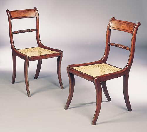 A set of four Regency mahogany and brass lined dining chairs