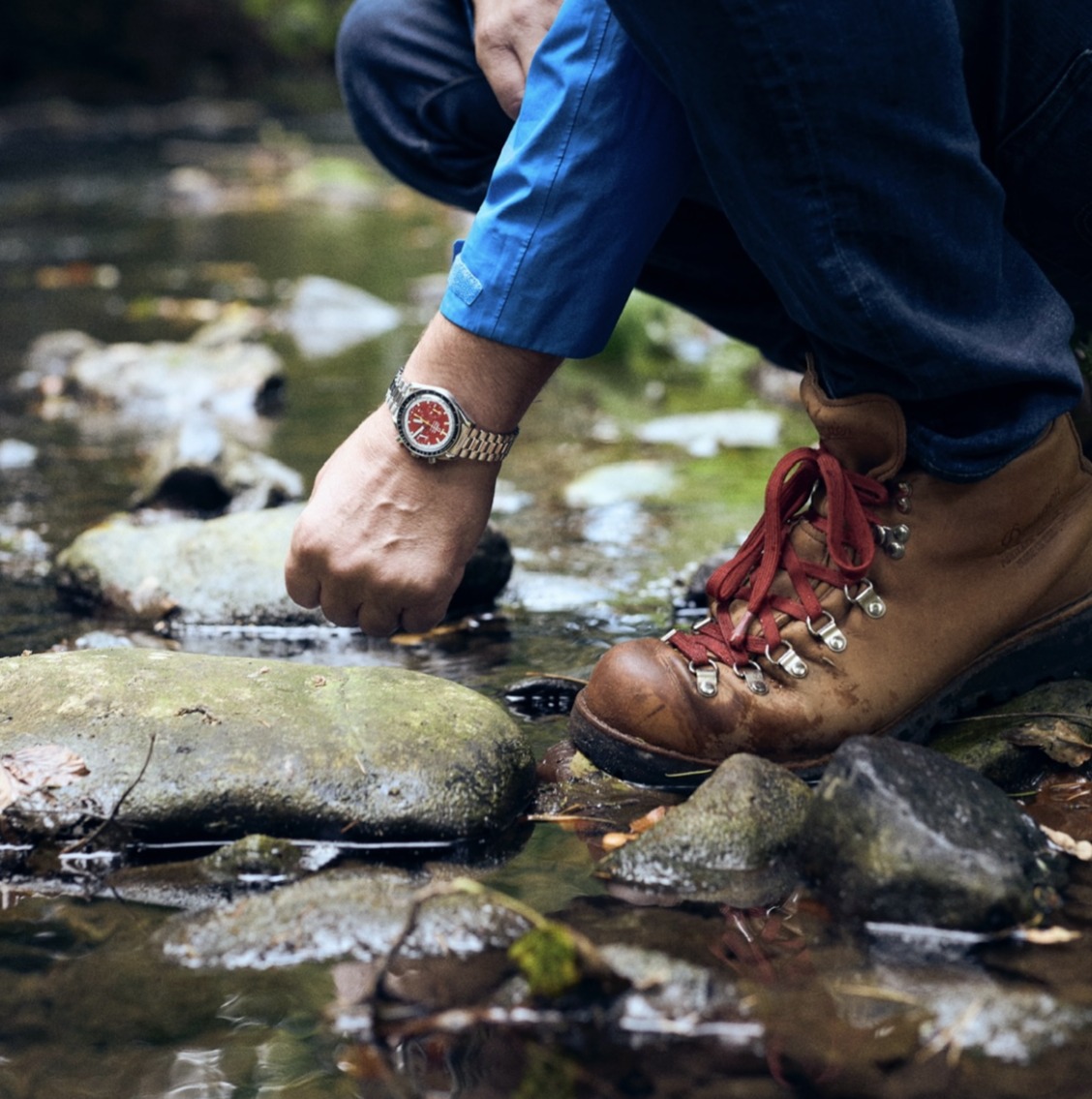 Omega. A stainless steel automatic chronograph wristwatch with red dial