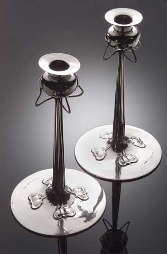 A pair of Liberty & Co. 'Cymric' silver candlesticks, the design attributed to Archibald Knox,