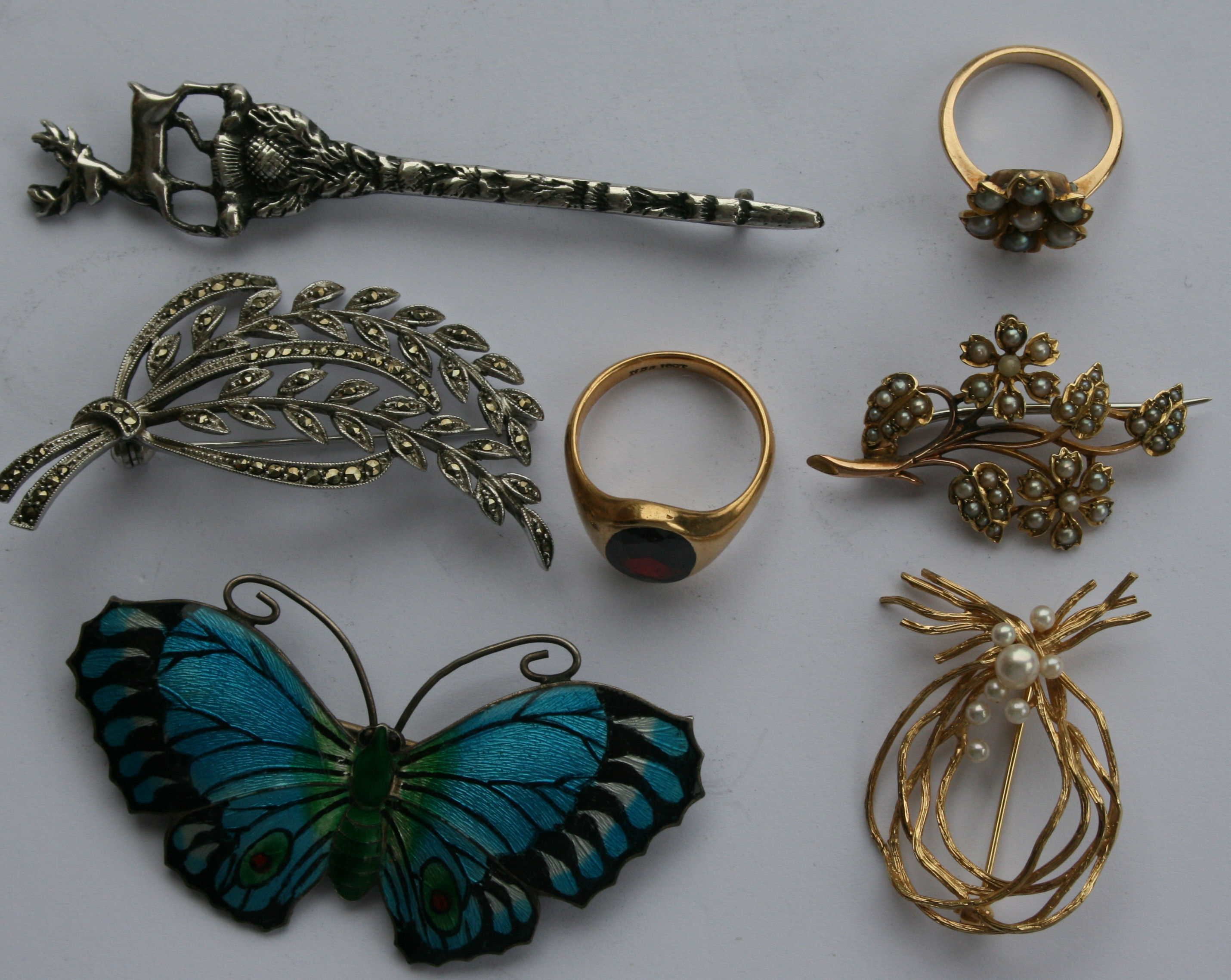 A group of various brooches to include