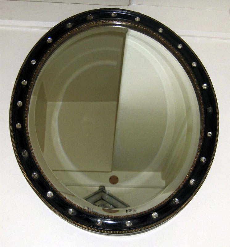An ebonised oval wall mirror