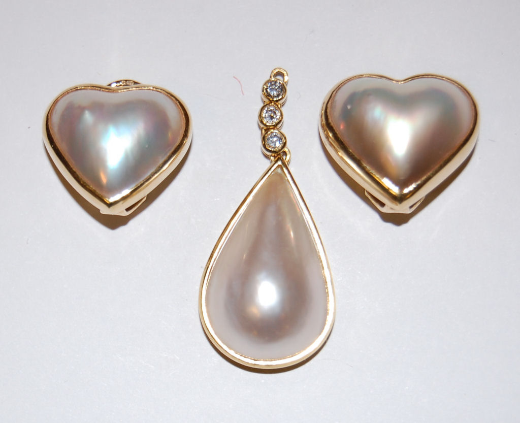 A pair of 18ct gold mabe pearl earrings and a similar pendant,