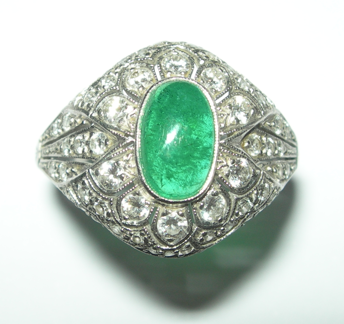 An early 20th century emerald and diamond cluster ring,