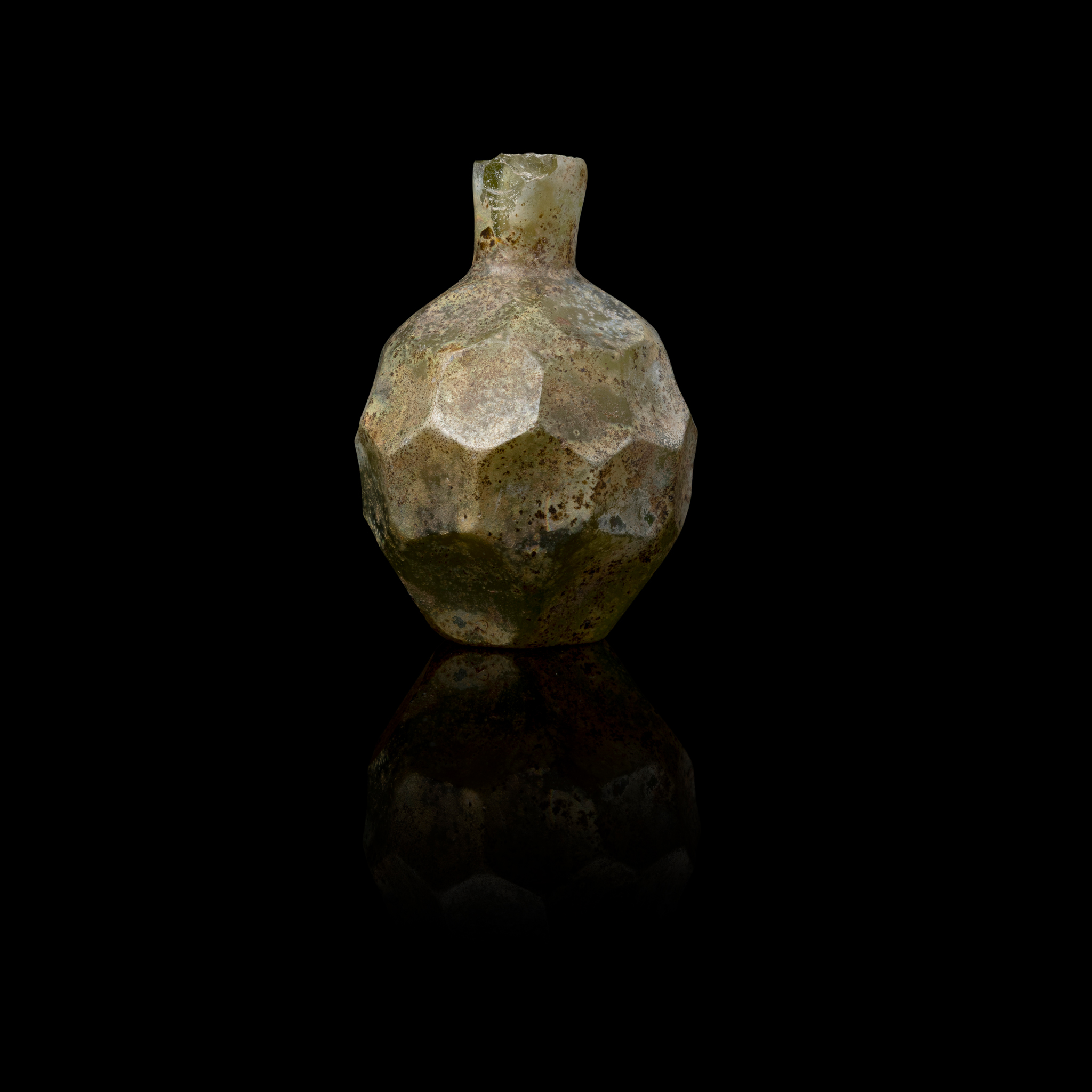 AN EARLY ISLAMIC FACETED MINIATURE PERFUME BOTTLE