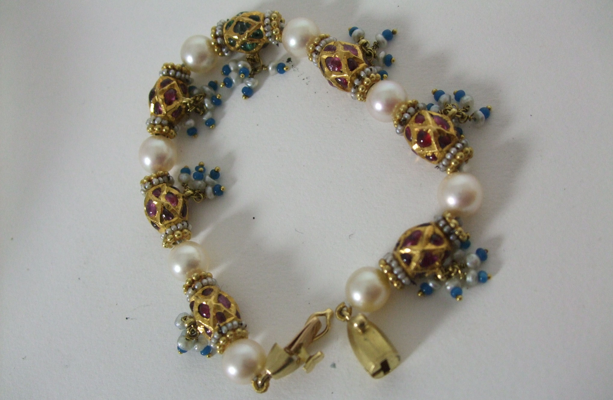 An Indian multi gem set 18ct gold and pearl bracelet
