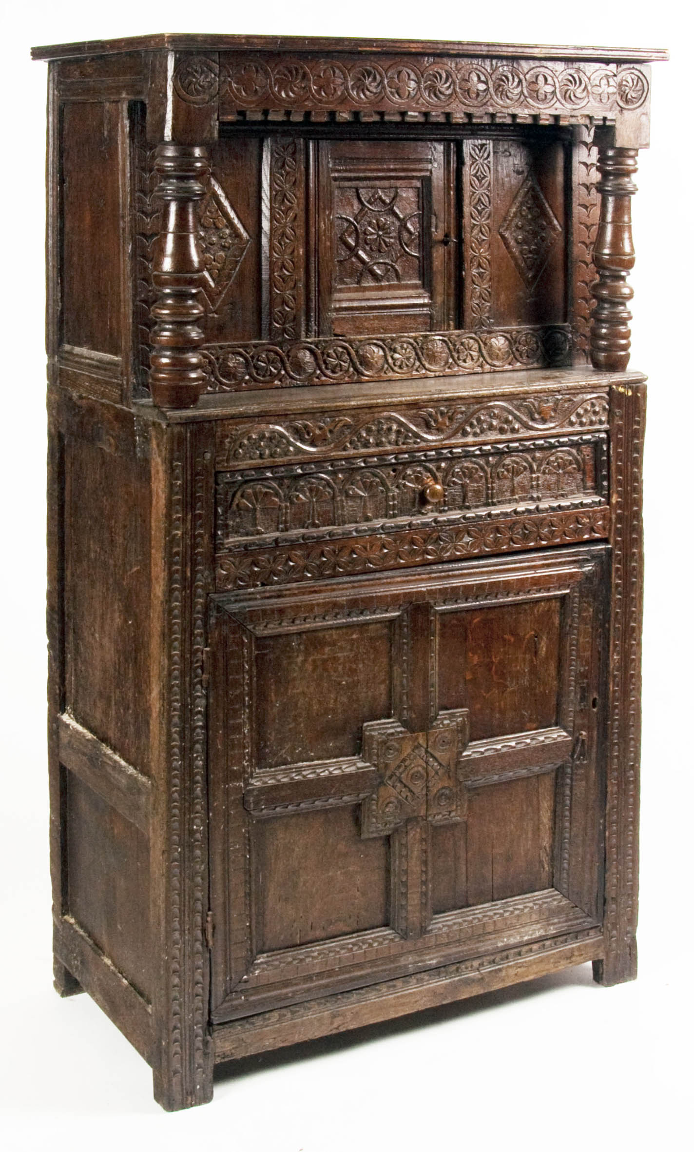 A 17th century style court cupboard with all over carving