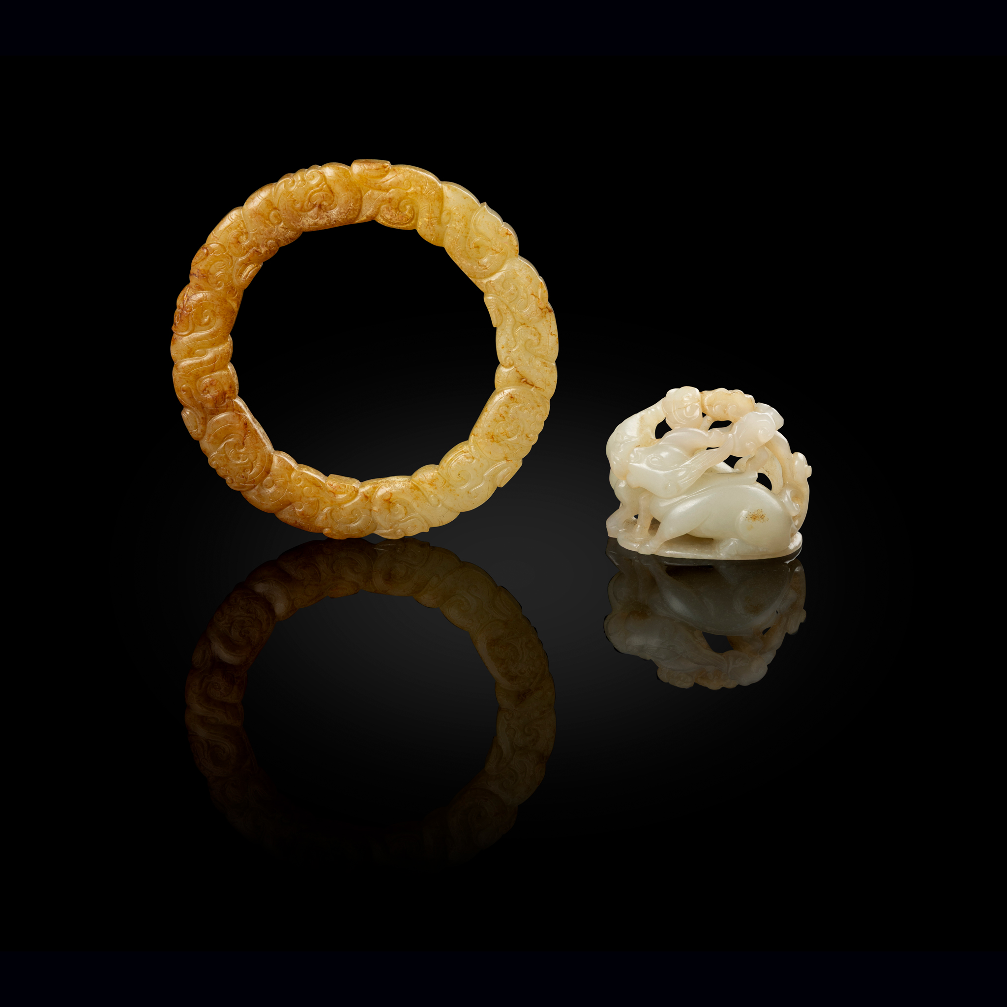 A CHINESE WHITE JADE 'DOUBLE DEER' HAT FINIAL AND A WHITE JADE WITH RUSSET INCLUSIONS 'DRAGON' RING