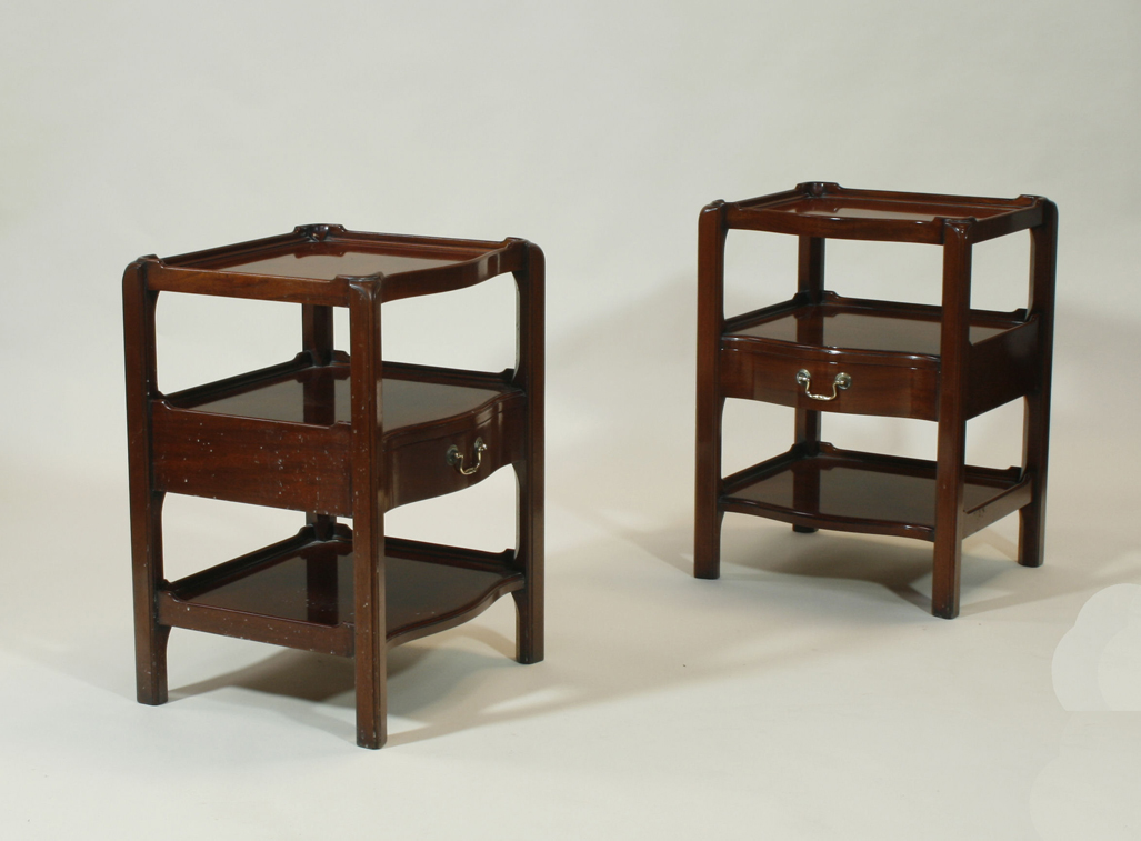 A pair of George III style mahogany serpentine bedside cabinets