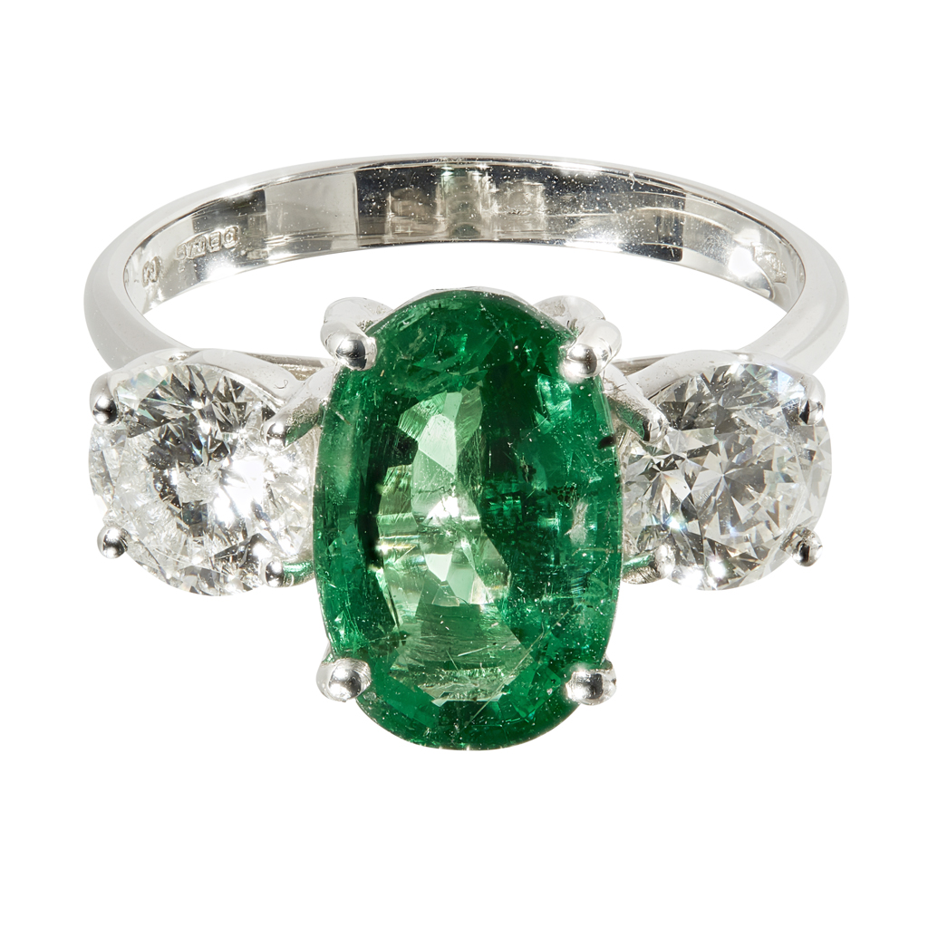 An emerald and diamond set three stone ring