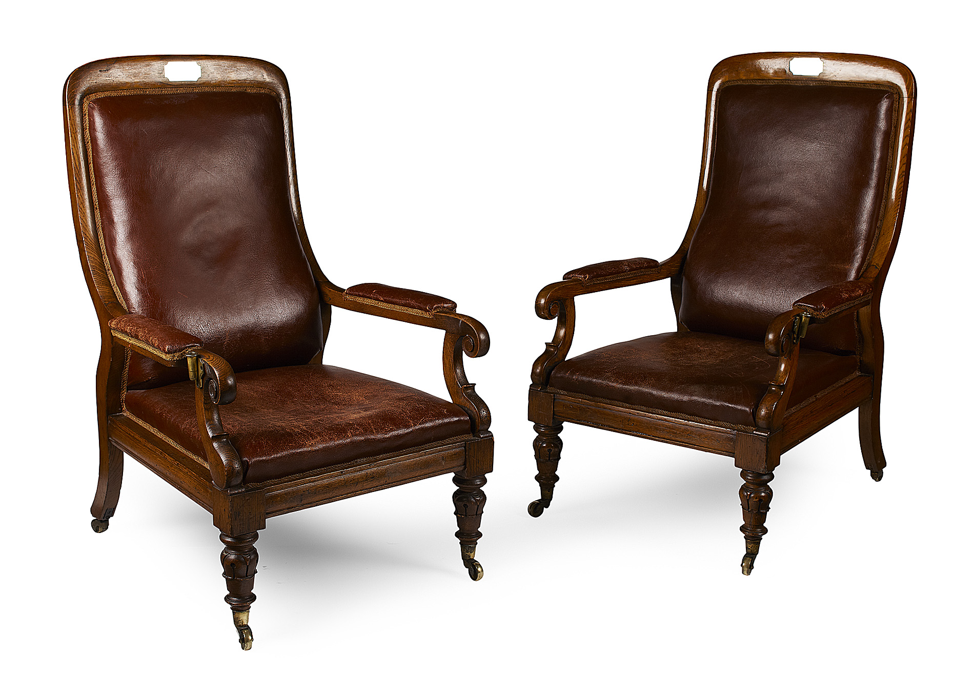 MARITIME INTEREST: PAIR OF EARLY VICTORIAN OAK FRAMED AND LEATHER UPHOLSTERED LIBRARY ARMCHAIRS