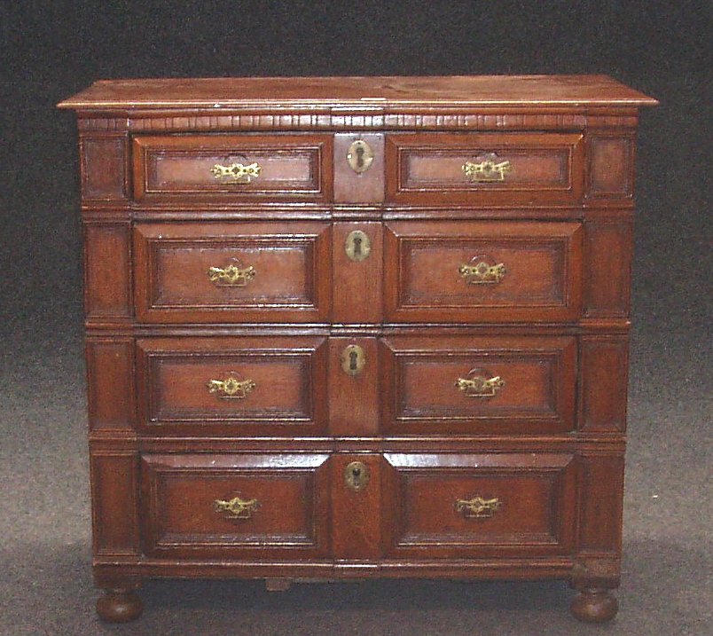 An oak chest of four graduated panelled drawers,