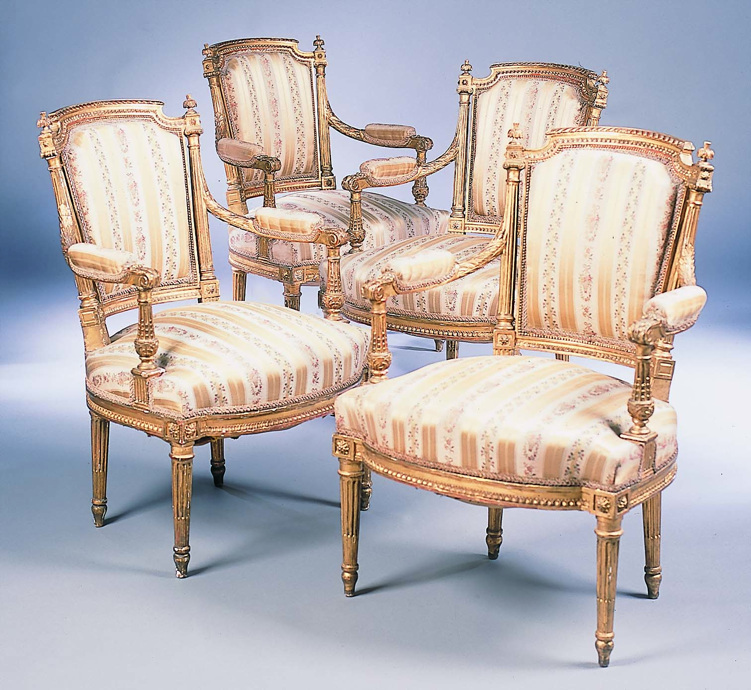 A set of four Louis XVI style giltwood fauteuils