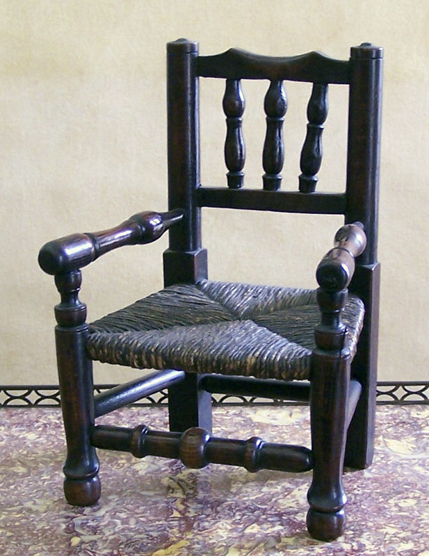 A miniature stained wood and rush upholstered country armchair