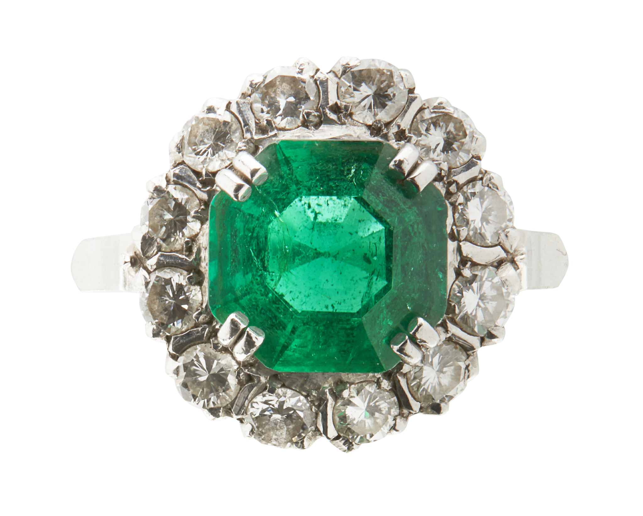 An emerald and diamond set cluster ring