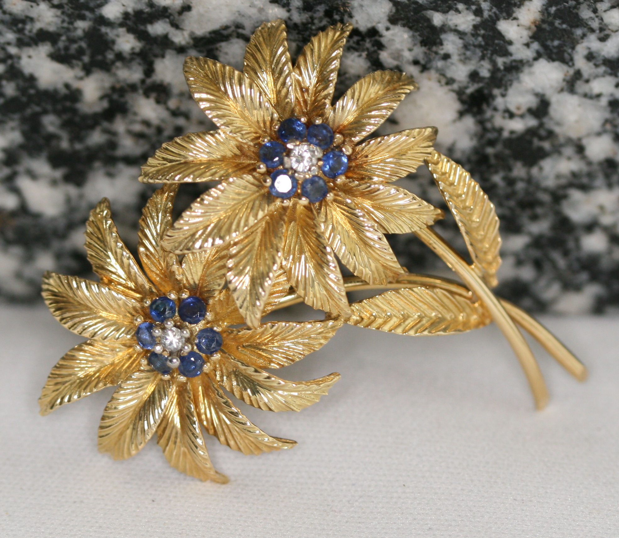 A 1960's 18ct gold mounted sapphire and diamond set floral brooch