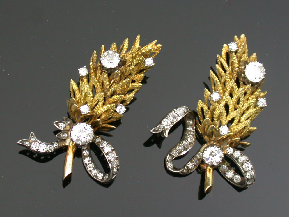 A pair of diamond set brooches,