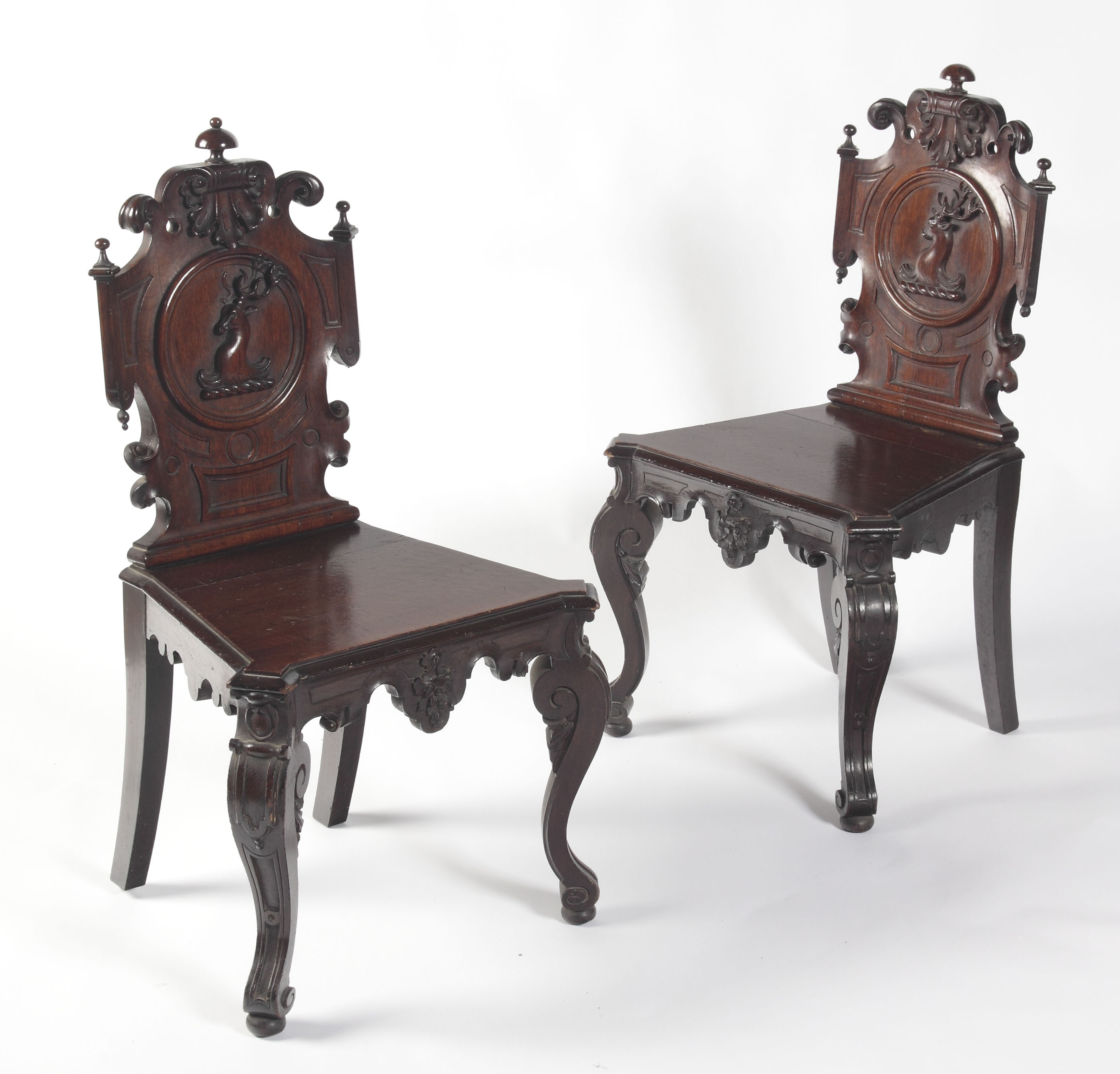 A pair of Victorian baronial oak carved hall chairs