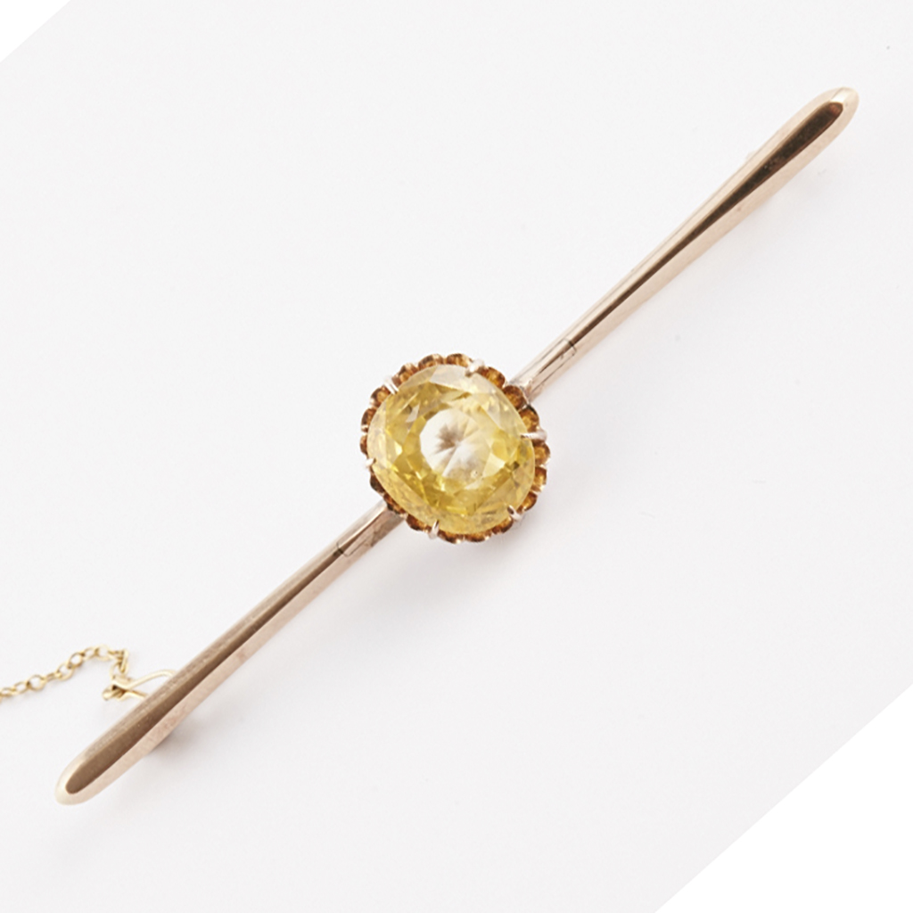 A yellow sapphire set bar brooch