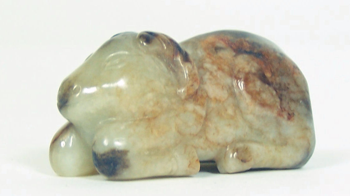 A Chinese pale and dark brown jade ram, Qing Dynasty