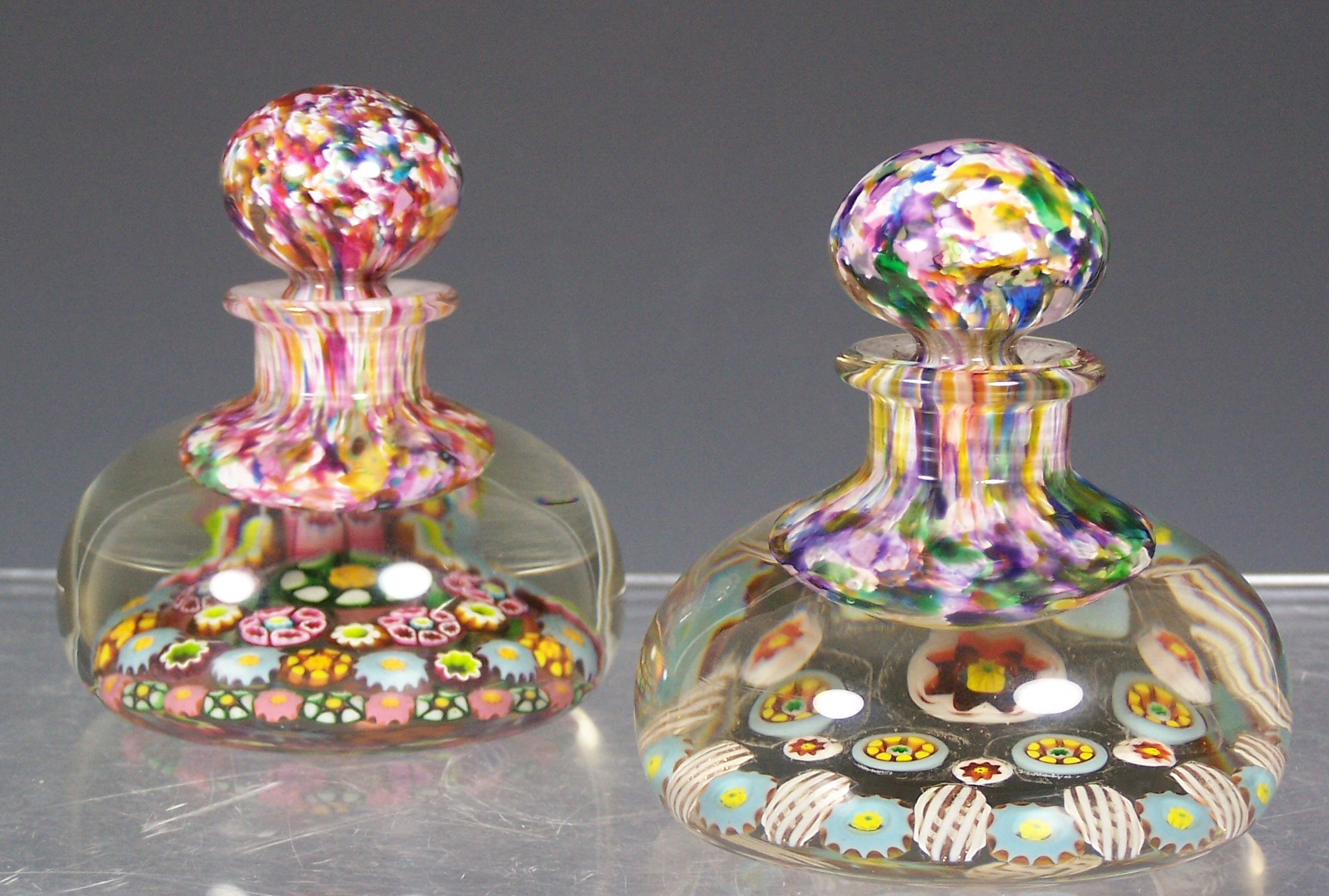 Two similar glass bottle paperweights and stoppers,