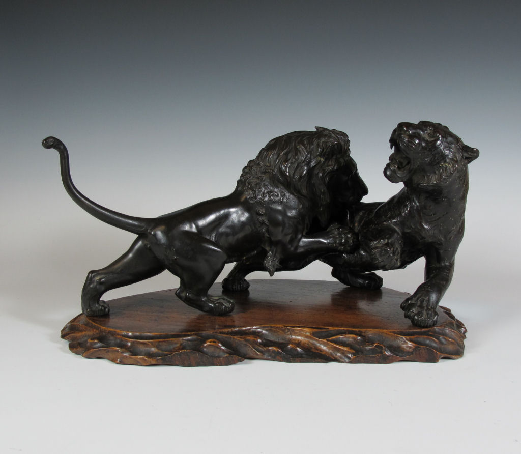 A Japanese bronze group of a lion attacking a tiger