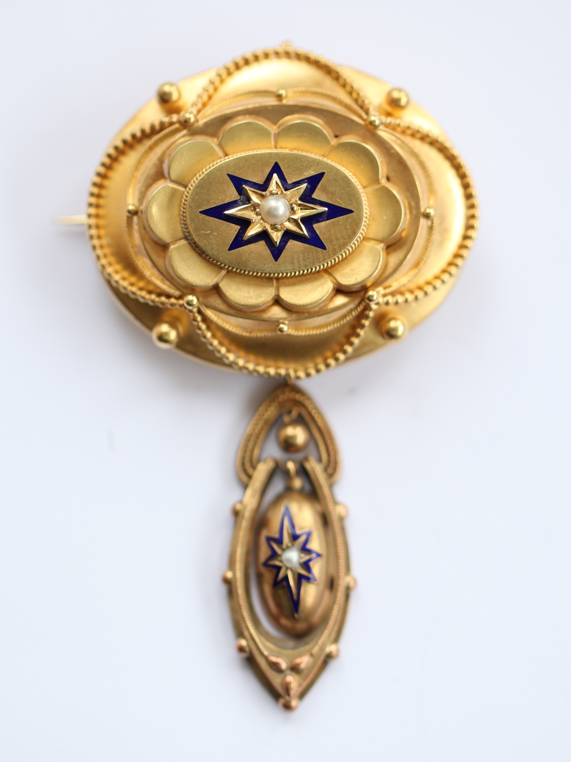 A Victorian seed pearl and enamel decorated brooch