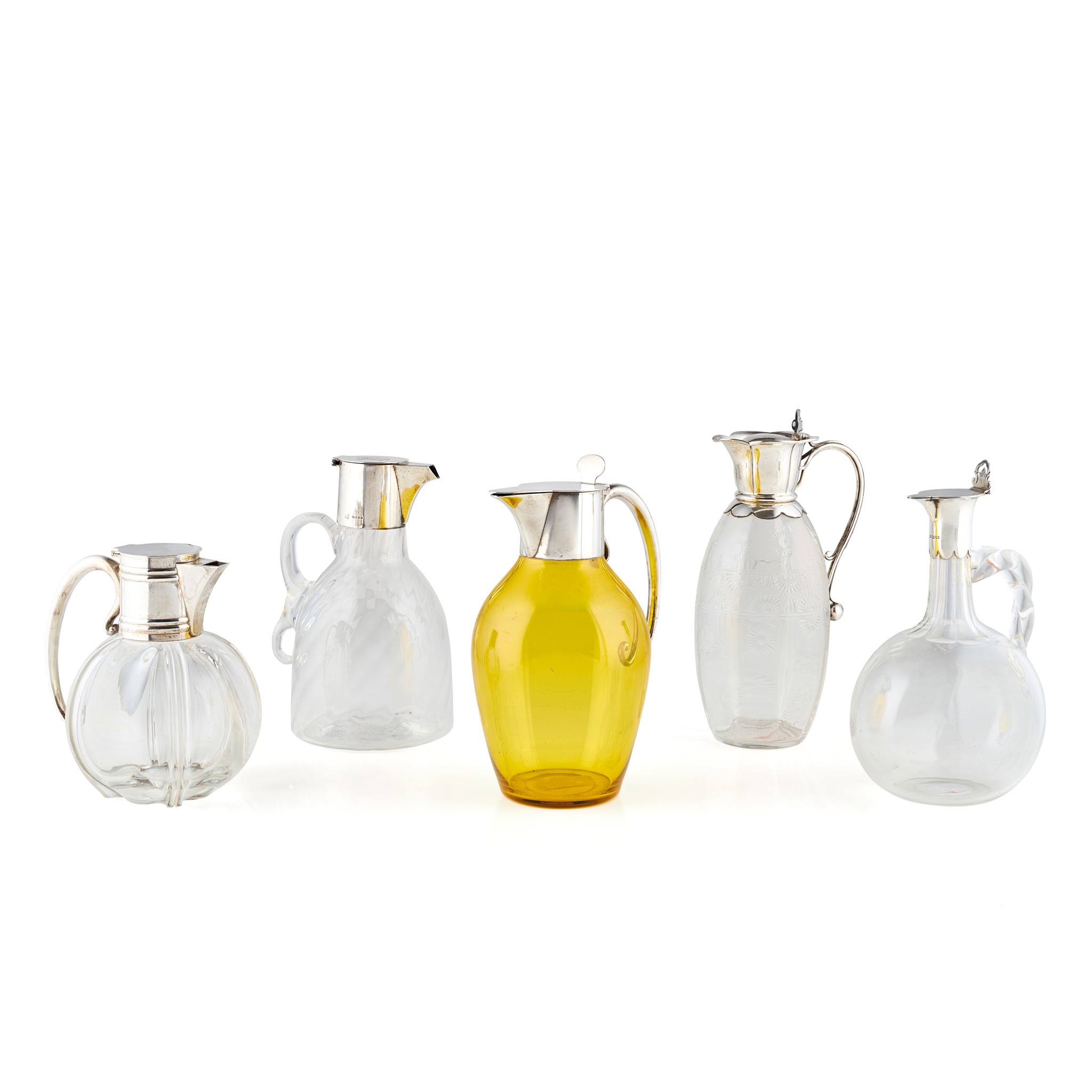 FIVE SILVER MOUNTED GLASS CLARET JUGS