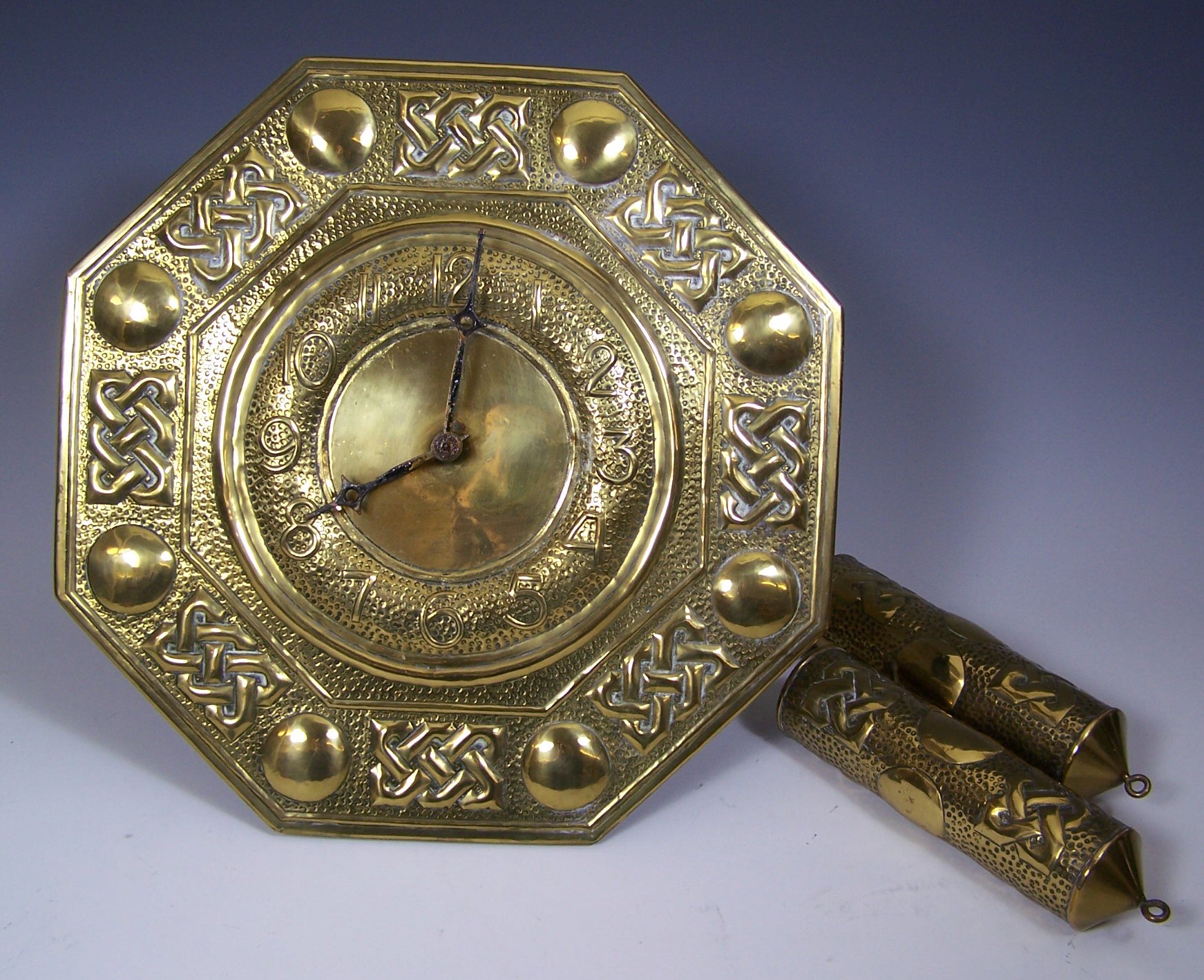 An octagonal faced brass pendulum wall clock,