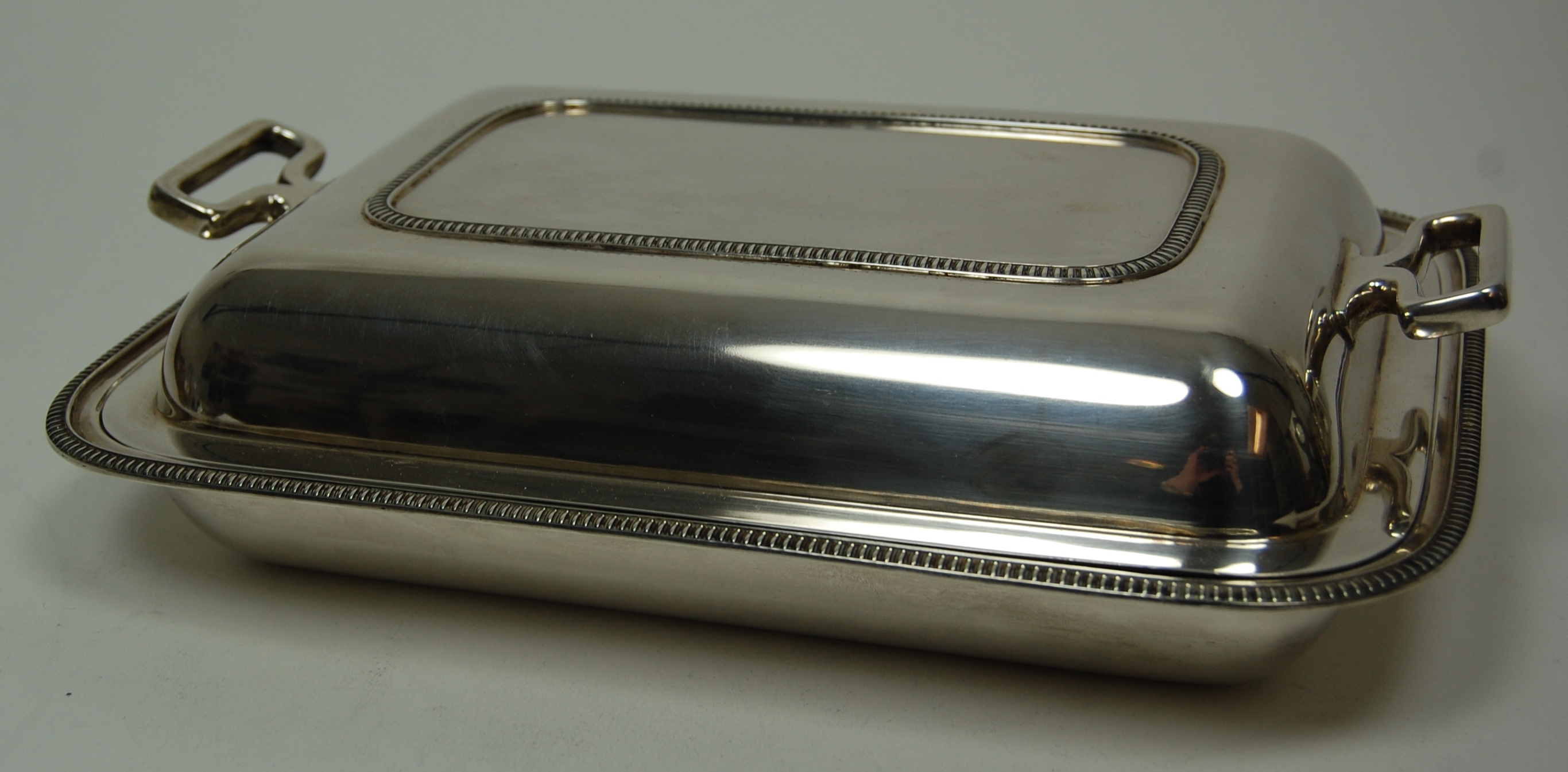 A modern entree dish and cover