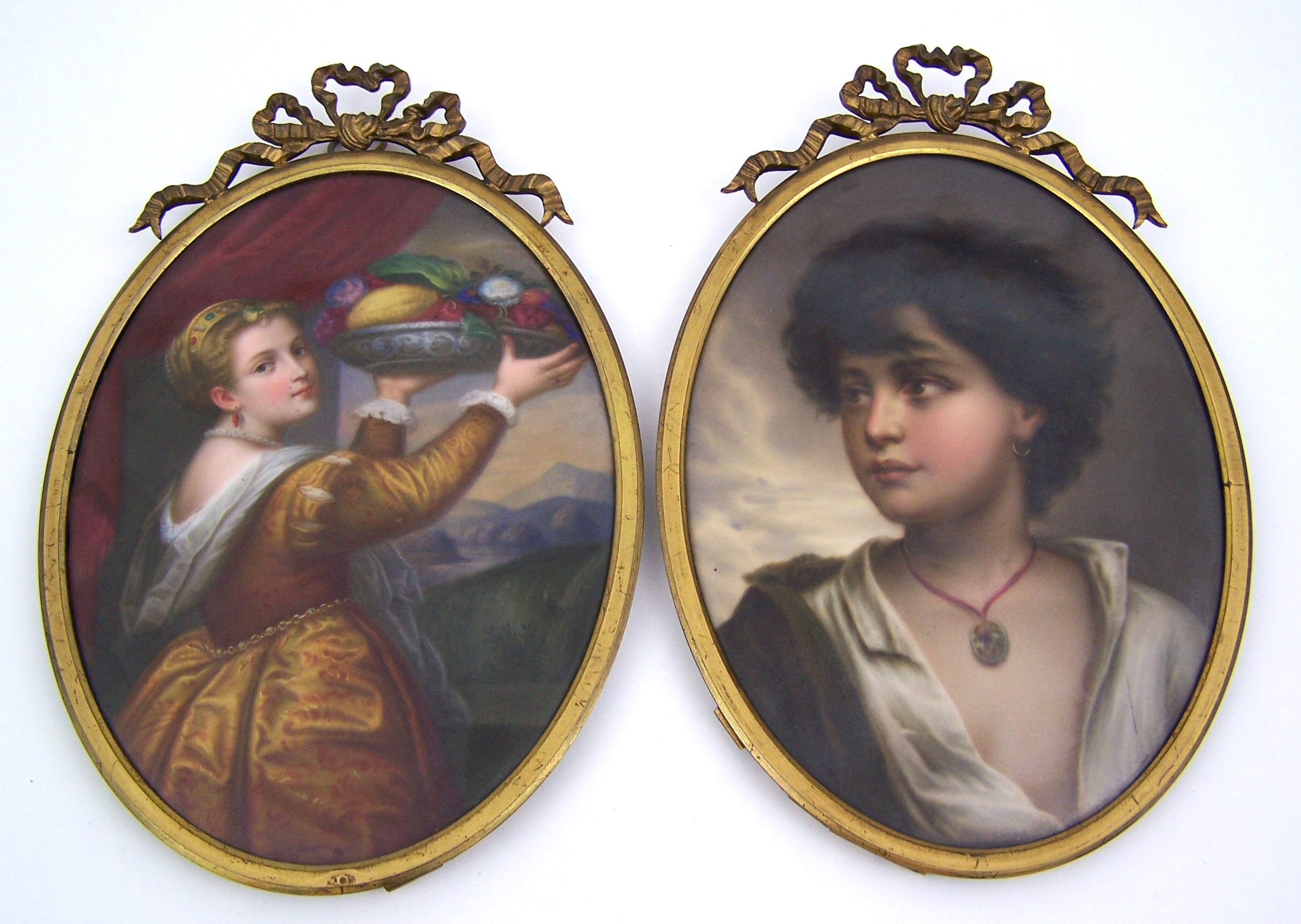 A pair of oval gilt framed painted porcelain panels,