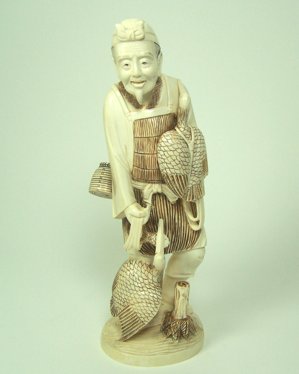 A large Japanese ivory figure of a man with two cranes, Meiji or Taisho period